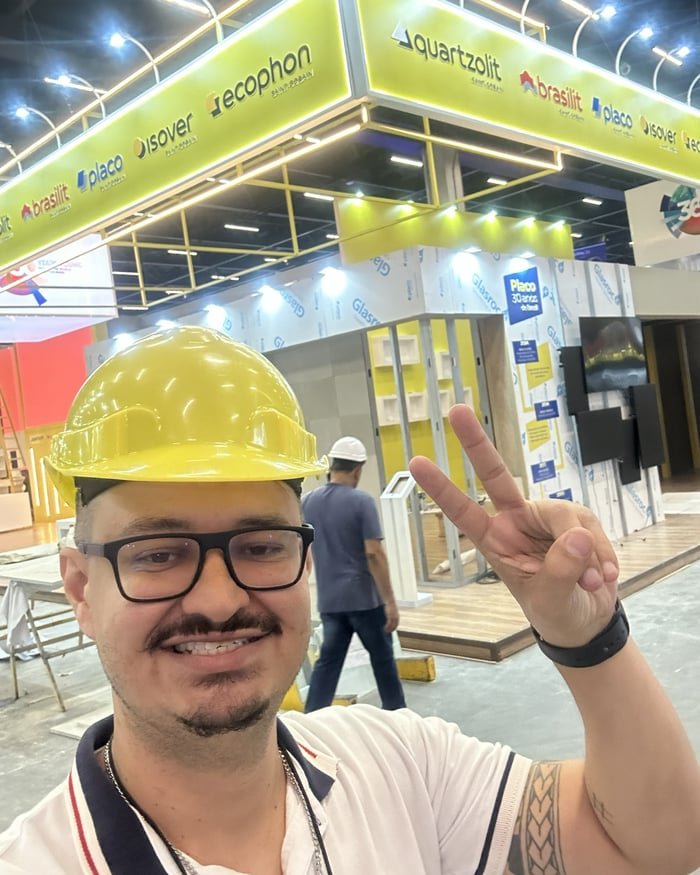 Camilo Leles de capacete no estande Saint-Gobain, com as marcas Quartzolit, Brasilit, Placo, Isover e Ecophon